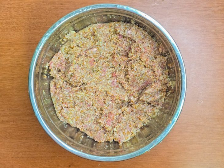 Mistura do liquidificador incorporada na tigela com carne e trigo.