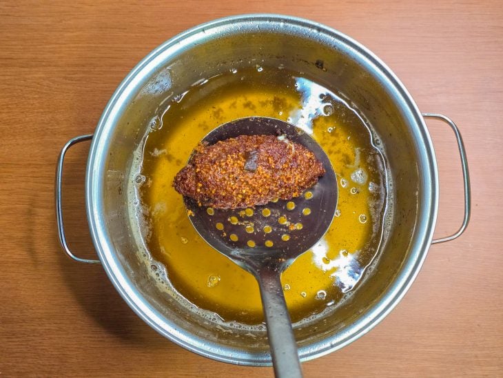 Quibe frito numa escumadeira.