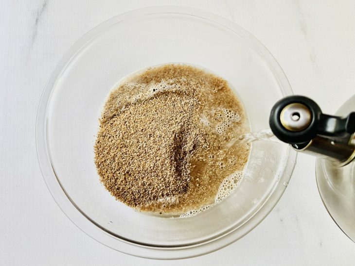 Água quente sendo despejada no recipiente com trigo.