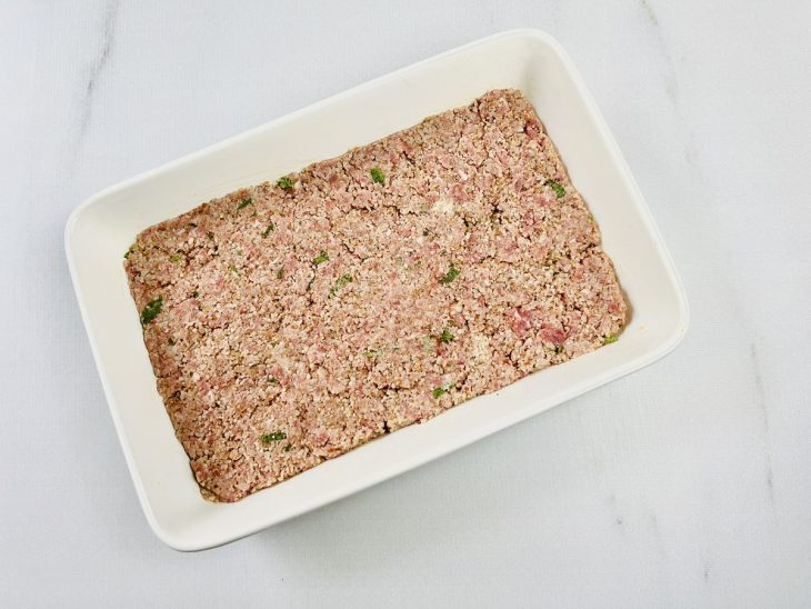 Metade da massa espalhada no recipiente.