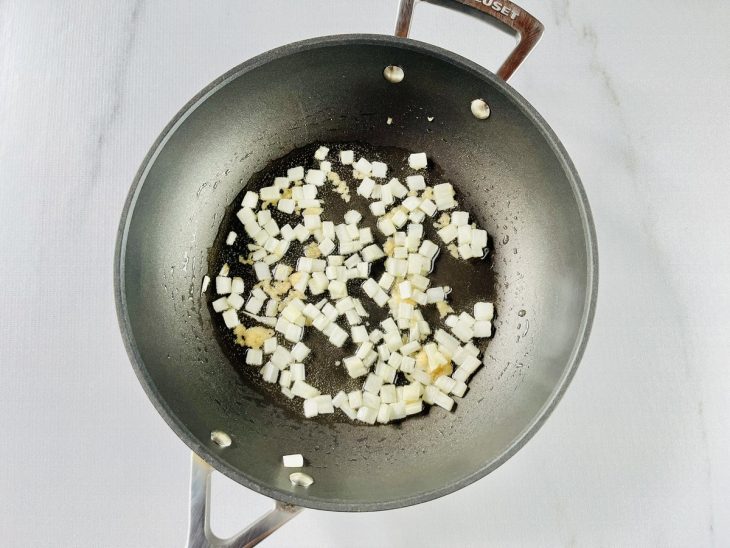 Alho e cebola refogando levemente na panela.