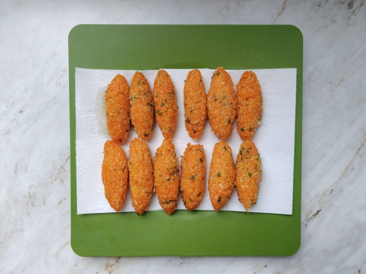 Quibes modelados em formato oval, prontos para fritar.