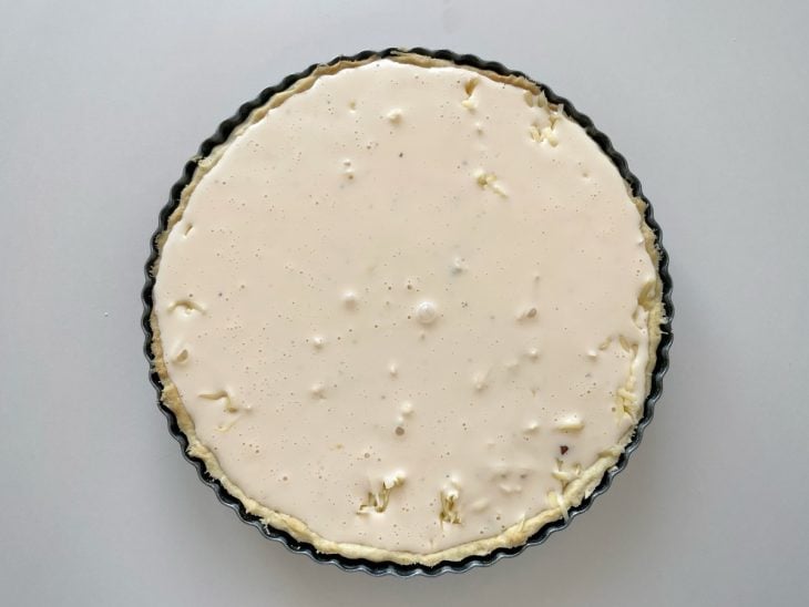Mistura líquida adicionada por cima do queijo e bacon.