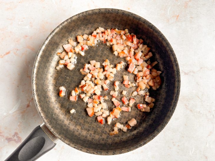 Bacon sendo dourado na panela até ficar crocante.