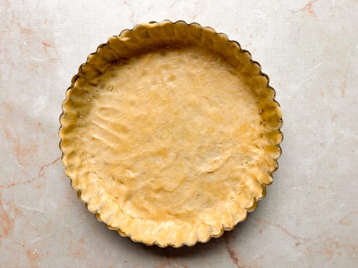 Massa forrando o fundo e as laterais da forma de fundo removível.