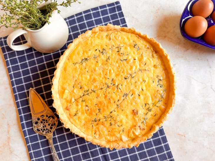 Quiche pronta, decorada com ramos de tomilho.