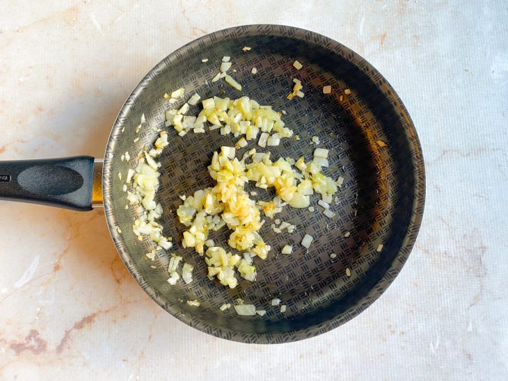 Alho e cebola dourando na panela.