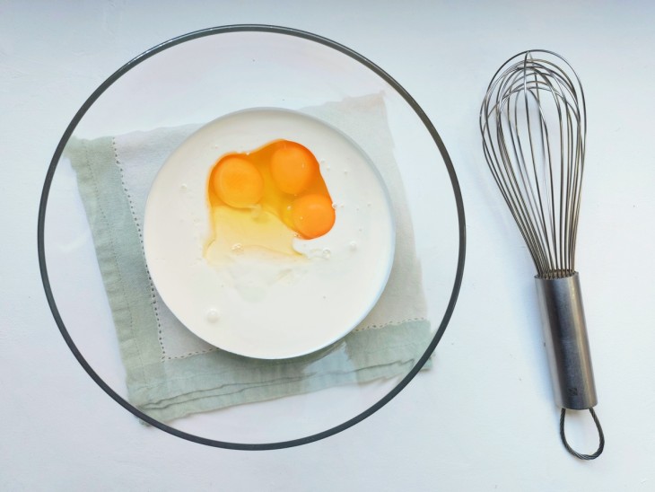 Um recipiente com a mistura de ovos, creme de leite e requeijão.