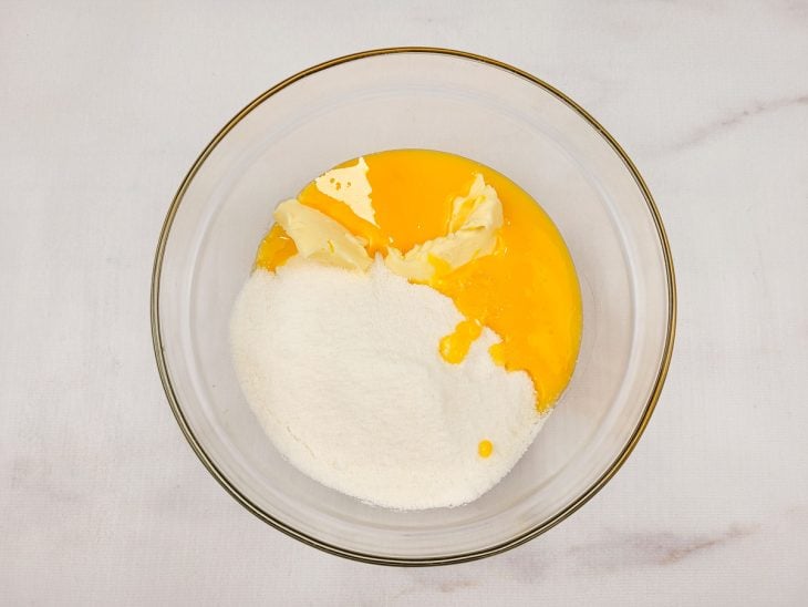 Gemas, manteiga e açúcar dentro de uma tigela.