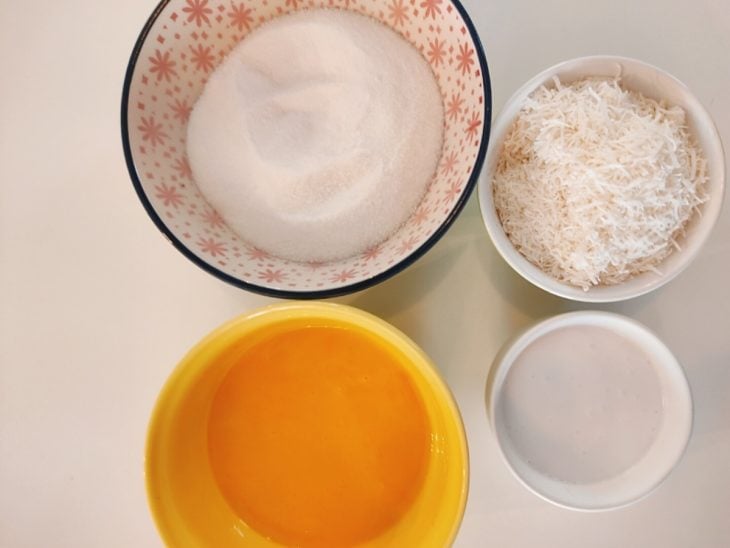 Ingredientes para a receita de quindim fácil separados em uma bancada.