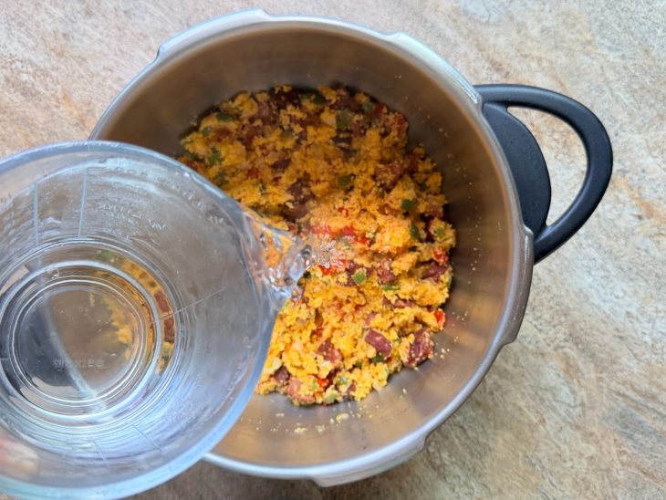 Na panela, água quente sendo adicionada.