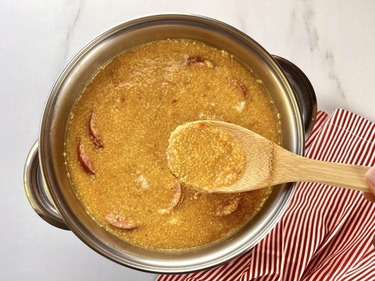 Uma panela com a mistura de todos os ingredientes da quirera com carne de porco.