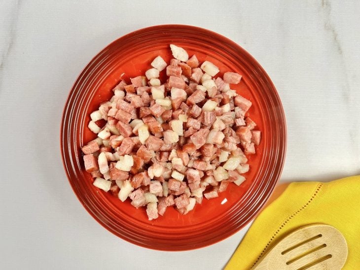 Uma tigela com bacon, calabresa, cebola e alho após dourar.