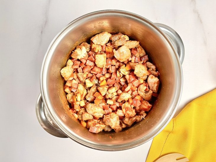 Uma panela com as costelinhas, bacon, calabresa e temperos.