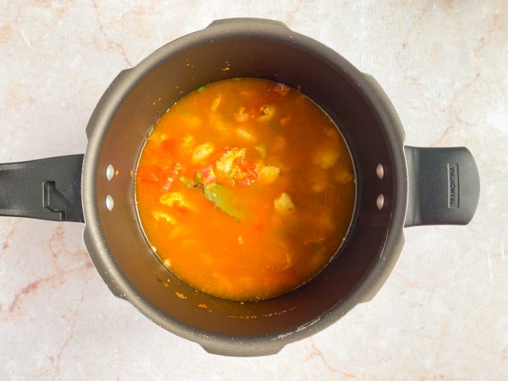 Na panela de pressão, ingredientes coberto pela água.