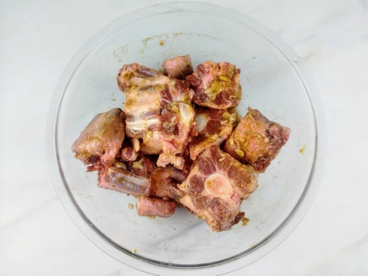 Carne com temperos descansando em uma tigela.