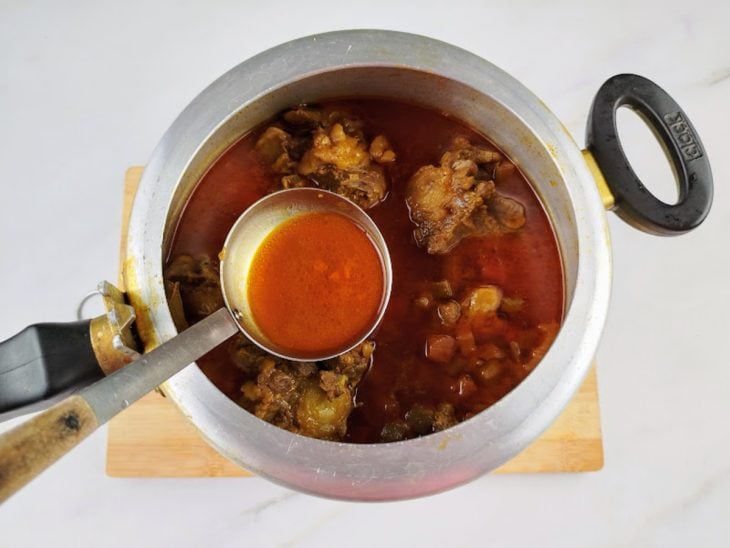 Gordura retirada por uma concha da panela de pressão.
