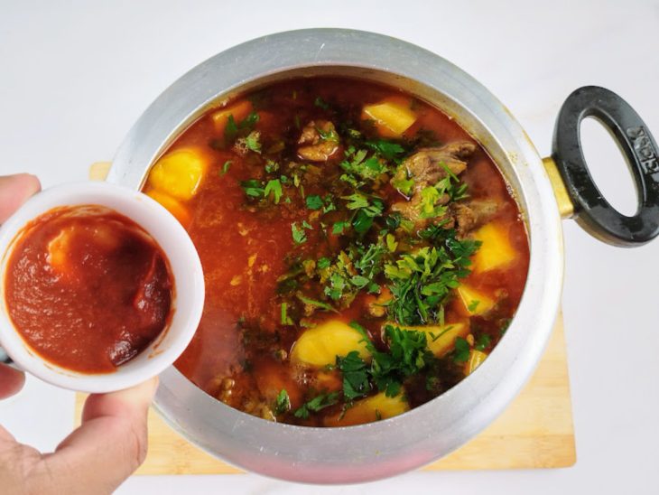 Extrato de tomate e cheiro verde picado adicionados na panela de pressão.