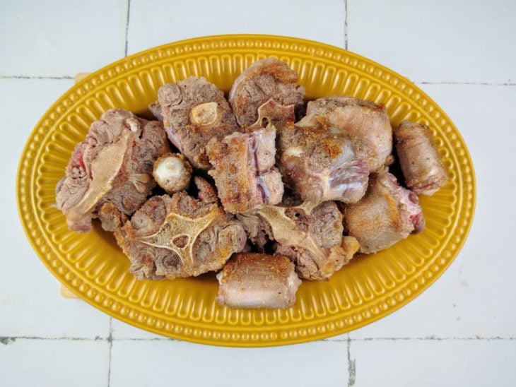 Um recipiente com a carne reservada após dourar na pressão.