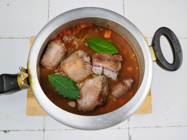 Uma panela com a rabada cozinhando.