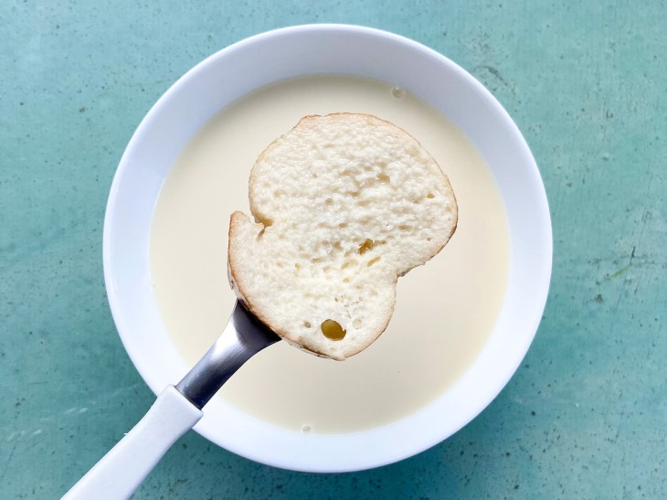 Uma fatia de pão molhado na primeira mistura.