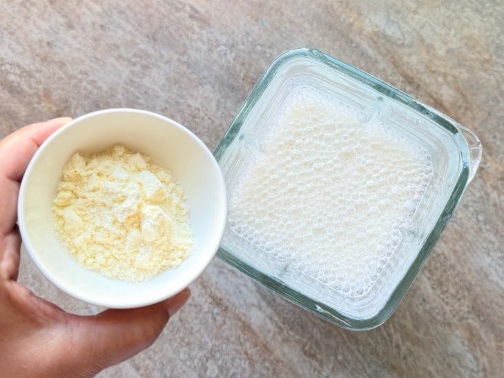 No liquidificador, o leite em pó sendo adicionado.