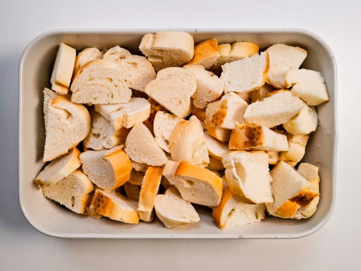 Rodelas de pão transferidas para o refratário untado.