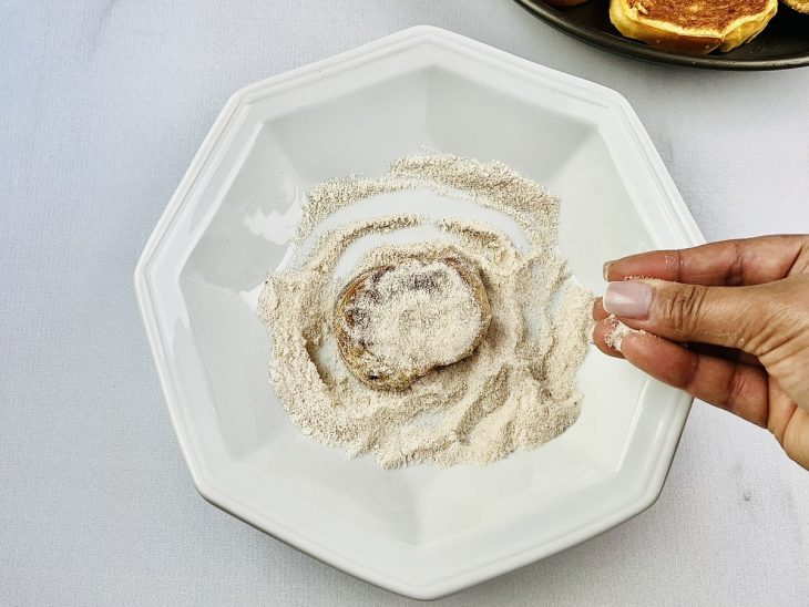 Rabanadas sendo empanadas no açúcar e canela.