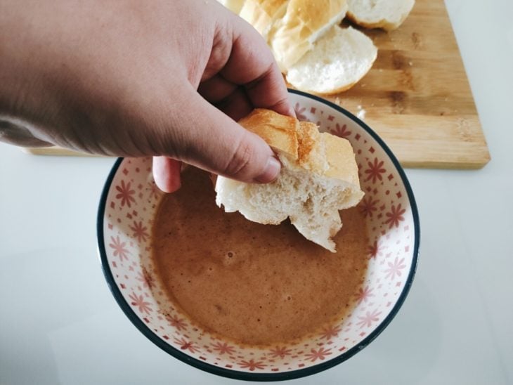 Fatia de pão molhada na mistura da tigela.