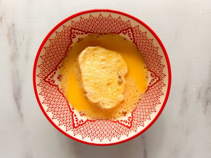 Rabanada passada na mistura de ovos.