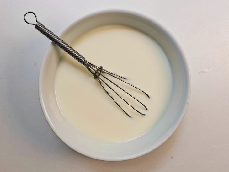 Calda de leite e leite condensado sendo misturada em tigela.