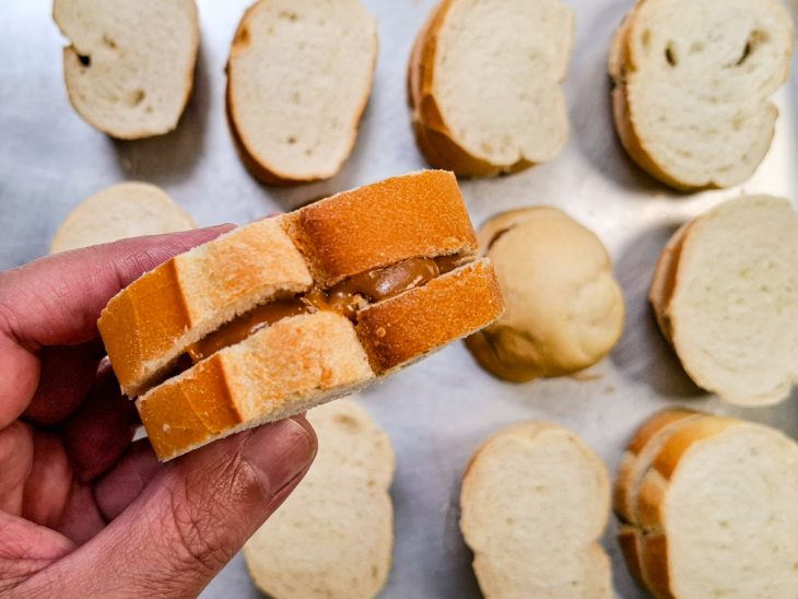 Pão sendo recheado.