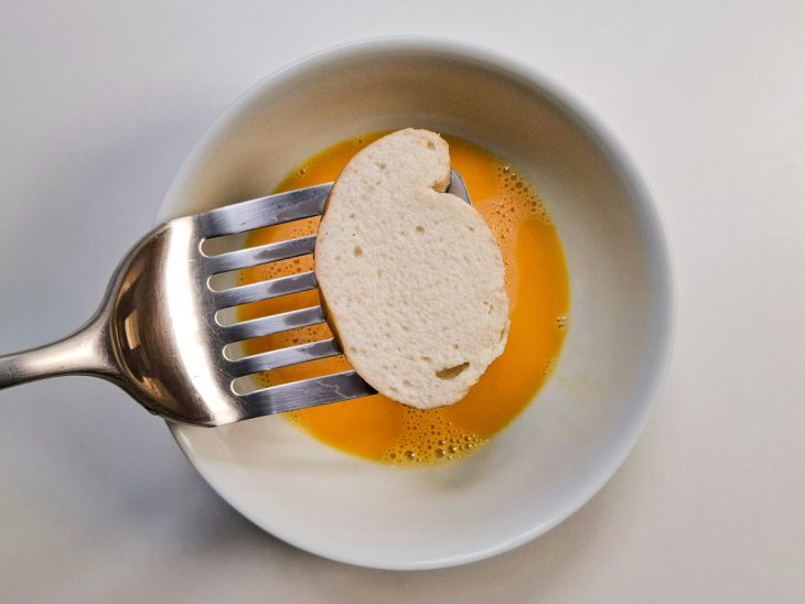 Fatias de pão mergulhada na mistura de ovos.