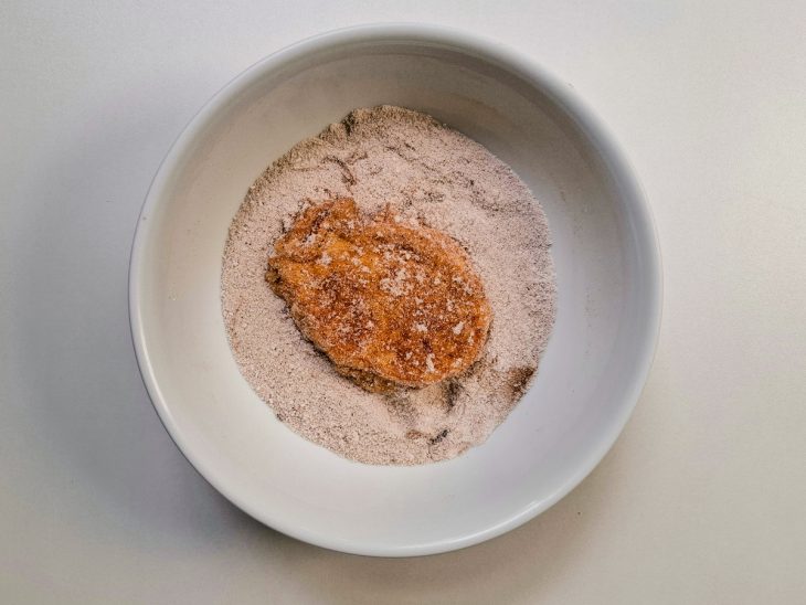 Rabanada passando na canela e açúcar.