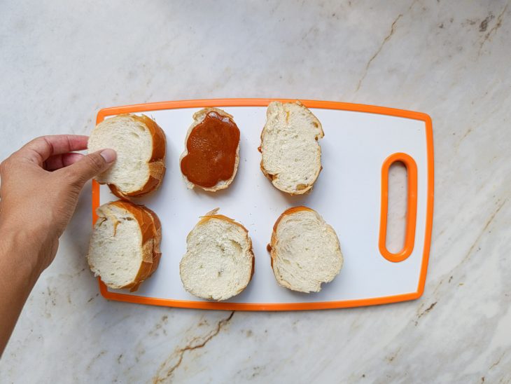 Fatias do pão sendo recheadas com o caramelo.