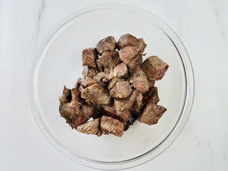 Carne reservada em uma tigela de vidro redonda.