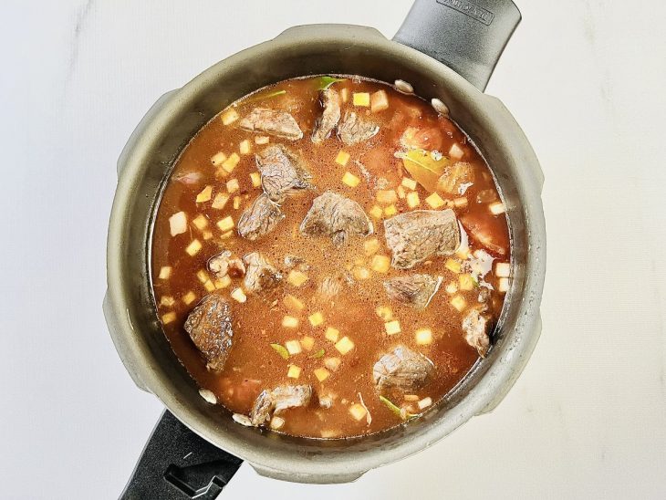 Carne colocada na panela de pressão.
