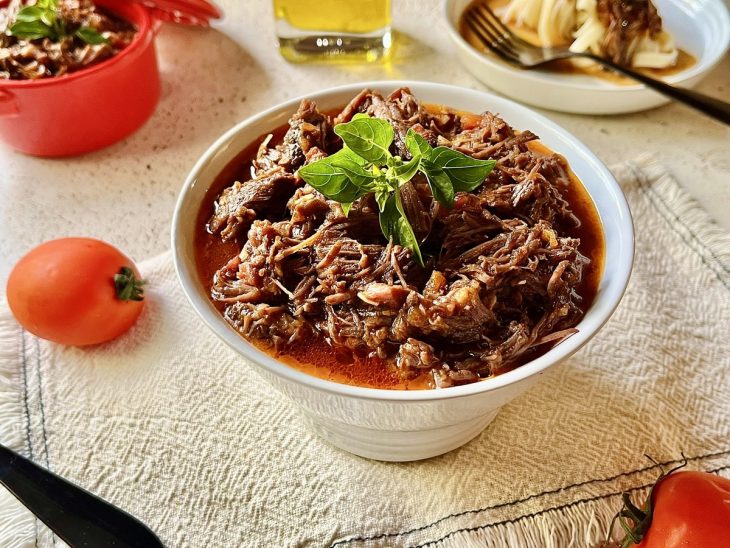 Ragu de carne servido em uma tigela redonda e pequena.