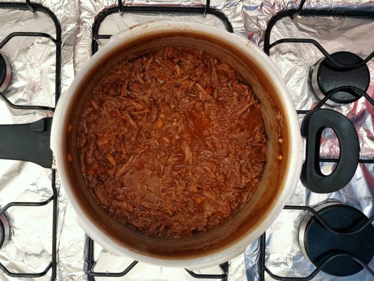 Carne desfiada e molho na panela de pressão.