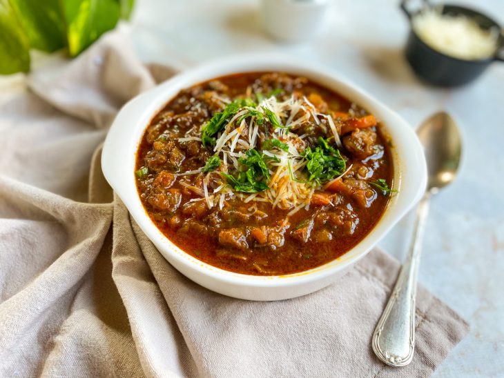 Ragu de ossobuco servido em um recipiente branco redondo.