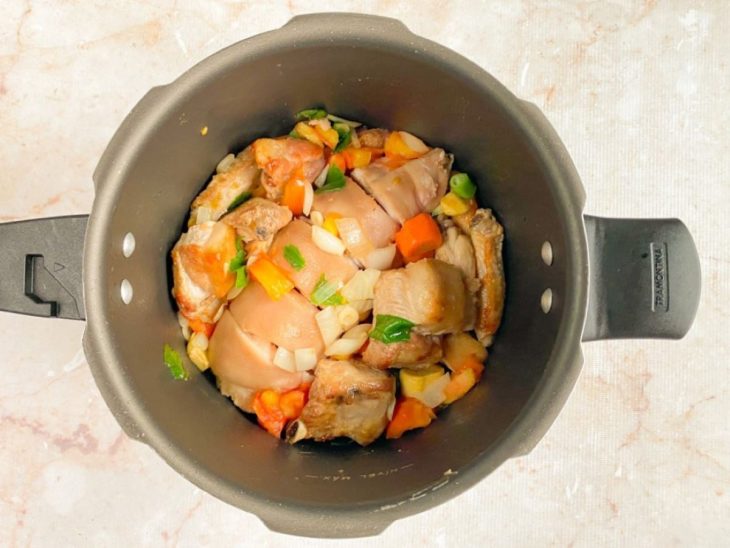 Uma panela com os vegetais e a carne a refogar.