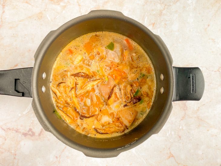 Uma panela com carnes, vegetais, páprica, extrato de tomate, shitake, missô, shoyu, saquê, mirin e o vinagre.