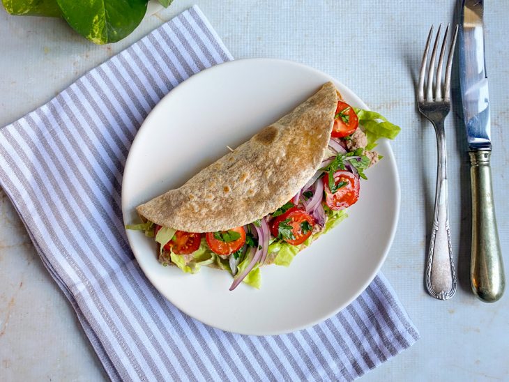 Rap10 pronta e fechada, servida em prato, com talheres ao lado.