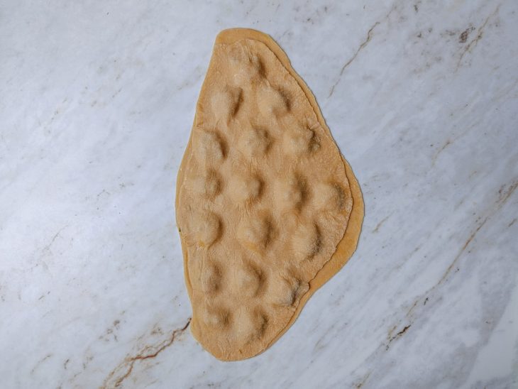 Recheio distribuído em pequenas porções sobre a massa.