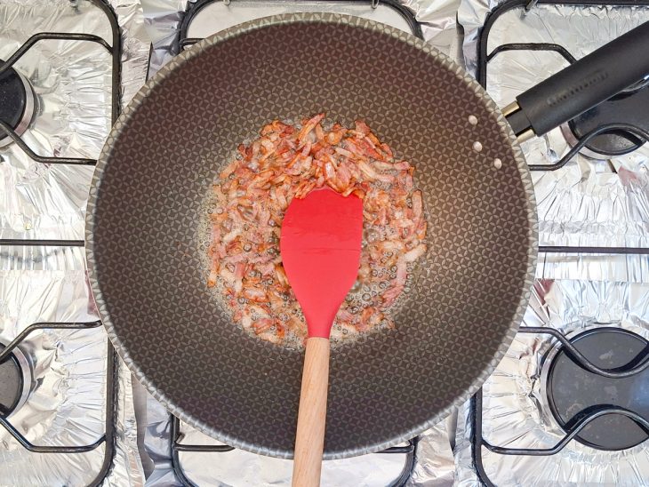 Bacon sendo frito em panela com manteiga derretida.
