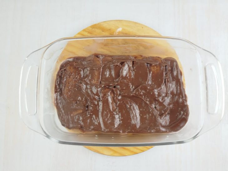 Na travessa, uma camada de bolacha e outra de creme.