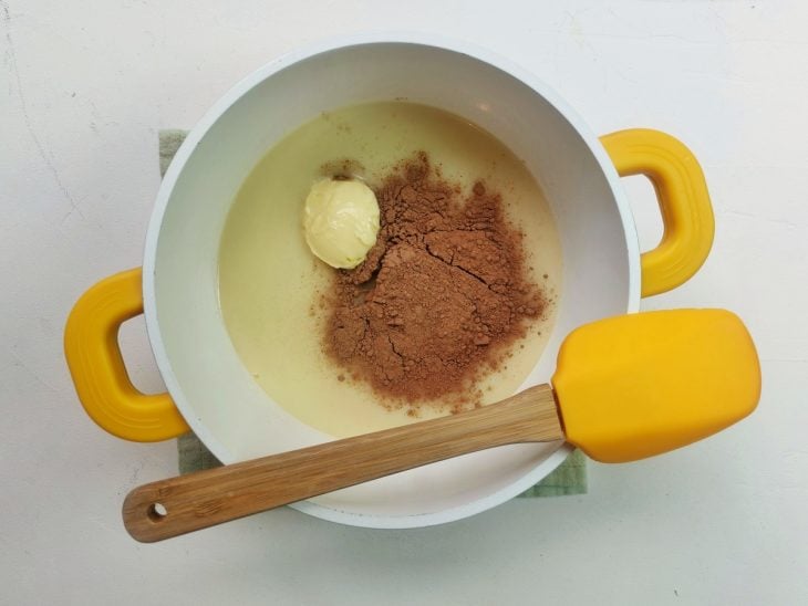 Uma panela contendo manteiga, cacau em pó e leite condensado.