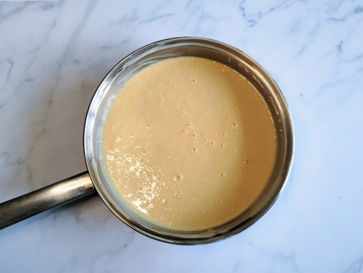 Uma panela contendo doce de leite, leite condensado e creme de leite.