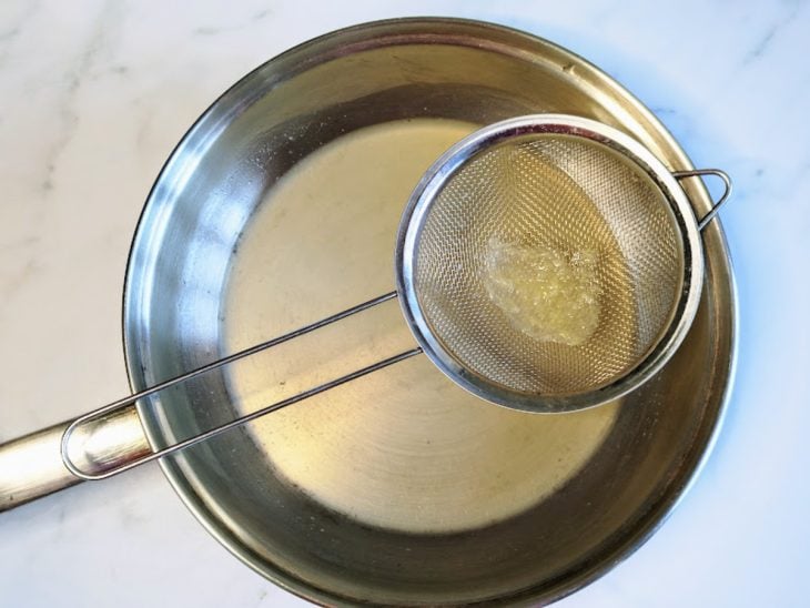 Uma panela com suco de limão peneirado.