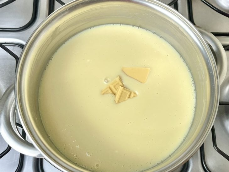 Uma panela contendo leite condensado, creme de leite e chocolate branco derretido.